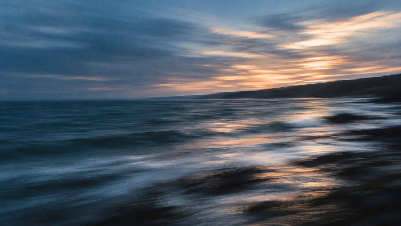 Soft evening light moving across a tidal shoreline